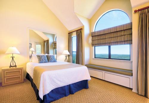 a bedroom with a bed and a large window at Club Wyndham Resort at Fairfield Bay in Fairfield Bay