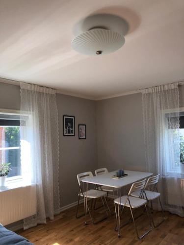 uma sala de jantar com uma mesa branca e cadeiras em Lindens Bed&Breakfast em Mellerud
