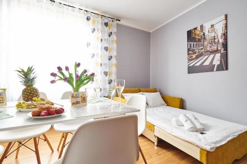 ein Wohnzimmer mit einem Tisch und einem Sofa in der Unterkunft JM Apartments zamieszkaj w Centrum in Krakau