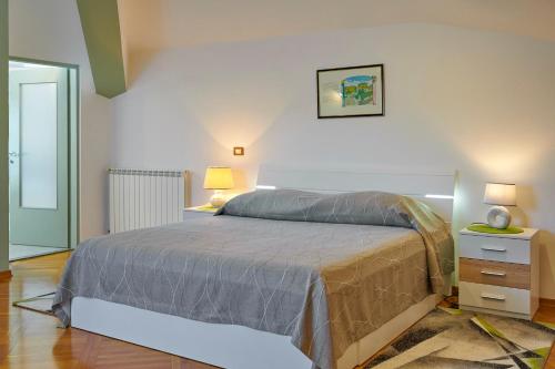 a bedroom with a bed and a night stand with two lamps at Villa Giardina Apartments in Vinkuran
