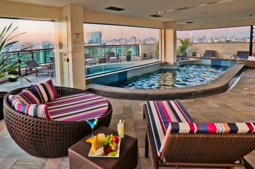uma piscina num hotel com duas cadeiras e uma mesa em Blue Tree Premium Faria Lima em São Paulo