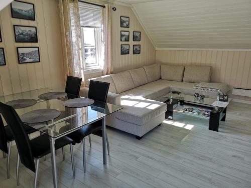 a living room with a couch and a table and chairs at Loftet, Nyksund in Nyksund