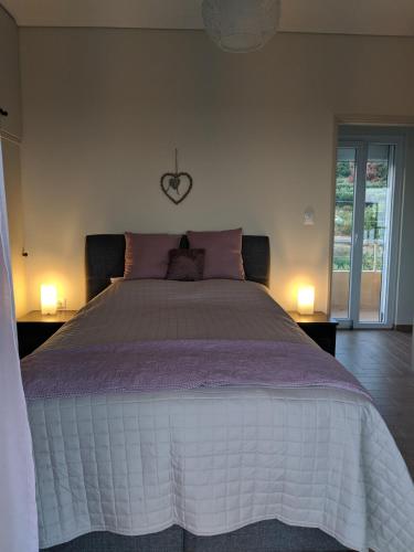 a bedroom with a large bed with a heart clock on the wall at Herodicus villa in Nea Skioni