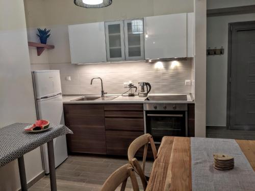 a kitchen with a sink and a refrigerator and a table at Herodicus villa in Nea Skioni