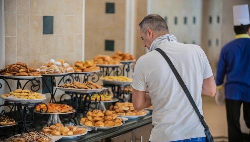 a man standing in front of a buffet of food at Blend Elphistone Resort Marsa Alam in Abu Dabab
