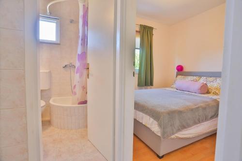 - une chambre avec un lit et une salle de bains pourvue d'une baignoire dans l'établissement Karlo’s apartments, à Split