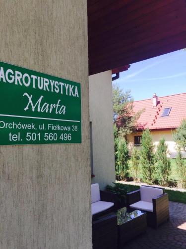 a sign for a marina with two chairs and a building at Marta in Okuninka