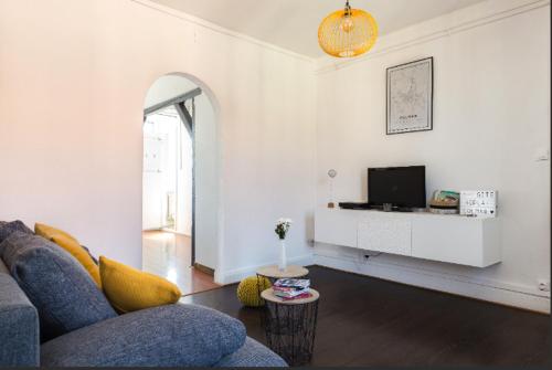 un salon avec un canapé et une télévision dans l'établissement Gîte Hopla 2 chambres, à Colmar