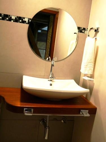 a bathroom with a sink and a mirror at Pousada Enseada Dos Golfinhos in Pipa