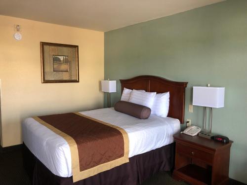 a hotel room with a bed and a telephone at Key West Inn - Tunica Resort in Tunica Resorts