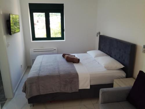 a bedroom with a large bed with a window at Olea in Tivat