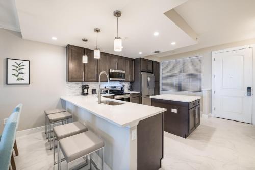 a kitchen with a sink and a counter with stools at Siena at Bella Collina in Montverde