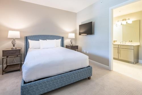 a bedroom with a white bed and a bathroom at Siena at Bella Collina in Montverde
