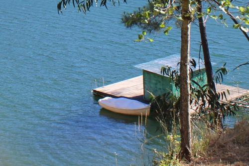 un pequeño muelle con un barco en el agua en Casa RioTempo + Jangada, en Tomar