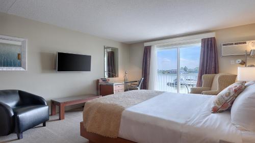 a hotel room with a bed and a large window at Auberge Handfield et Spa in Saint-Marc-sur-Richelieu