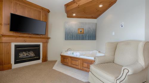 a living room with a fireplace and a television at Auberge Handfield et Spa in Saint-Marc-sur-Richelieu
