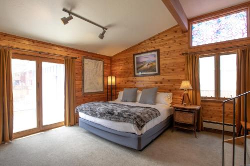 a bedroom with a bed in a room with wooden walls at Purple Mountain Bed & Breakfast & Spa in Crested Butte
