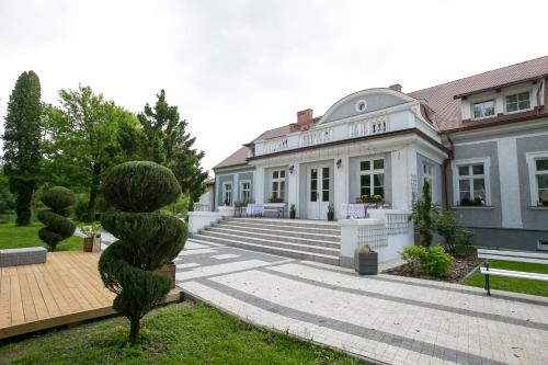 um edifício com uma estátua em frente em Mazurski Dwór em Olecko