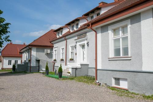 a row of white houses with a gravel driveway at Mazurski Dwór in Olecko
