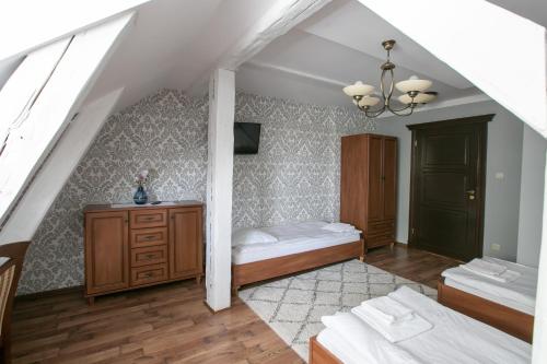 a attic bedroom with two beds and a dresser at Mazurski Dwór in Olecko