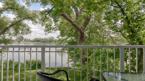 a balcony with a view of a lake with a tree at Auberge Handfield et Spa in Saint-Marc-sur-Richelieu