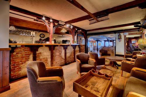 a room with a bar with chairs and a table at Auberge Handfield et Spa in Saint-Marc-sur-Richelieu