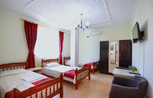 um quarto com duas camas e uma cadeira em My Home Guest House em Durrës