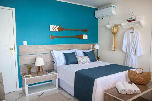 a bedroom with a large bed with a blue wall at Recanto do Sol in Praia de Araçatiba