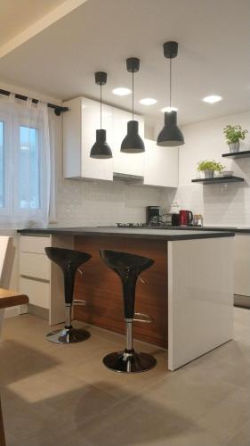 a kitchen with black bar stools in a kitchen at Apartments Gina in Trogir