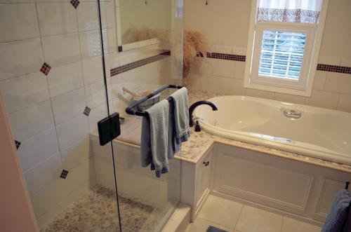 ein Badezimmer mit einer Dusche, einer Badewanne und einem Waschbecken in der Unterkunft The Lace Curtain Cottage in Chadwicks