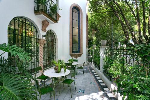 墨西哥城的住宿－Orchid House Polanco，户外庭院配有桌椅和树木。