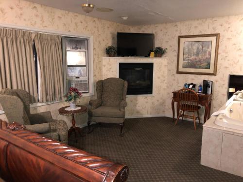 a living room with two chairs and a television at Afton House Inn in Afton