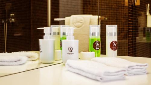 eine Badezimmertheke mit mehreren Flaschen Seife und Handtüchern in der Unterkunft Agrinho Suites & Spa Gerês in Valdosende