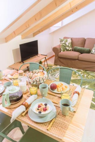 a table with plates of food on it in a living room at Living Coimbra Corpo de Deus in Coimbra