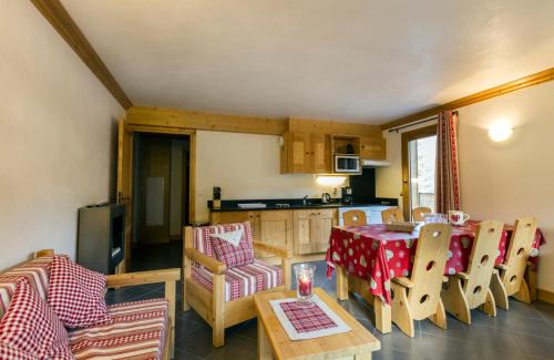 a kitchen and dining room with a table and chairs at Résidence Le Critérium in Lanslebourg-Mont-Cenis