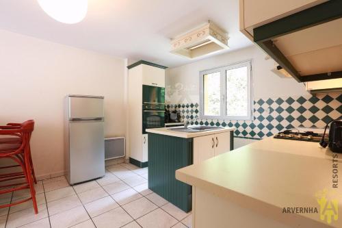 une cuisine avec un réfrigérateur et un plan de travail dans l'établissement Rev'O'Lac 2, à Chambon-sur-Lac