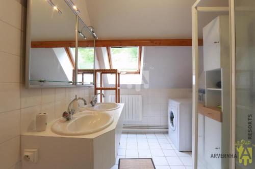 ein Badezimmer mit 2 Waschbecken und einer Waschmaschine in der Unterkunft Rev'O'Lac 2 in Chambon-sur-Lac