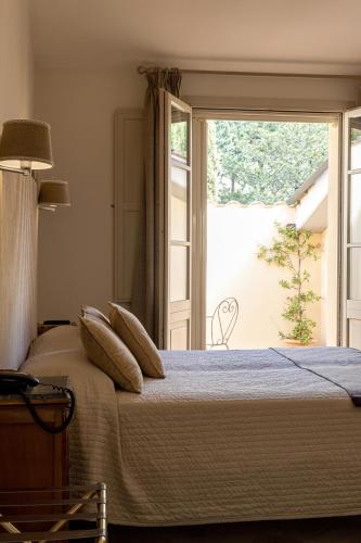 a bedroom with a bed and a large window at Si Montalcino Hotel in Montalcino