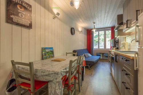 a kitchen and dining room with a table and chairs at Le Petit Lutess in Murol
