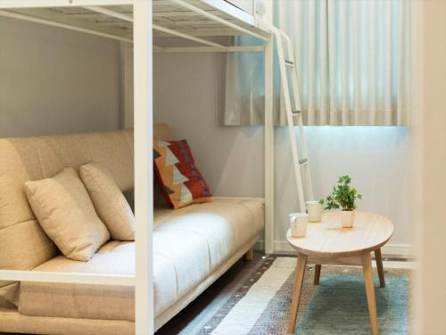 a living room with a couch and a table at TRIP POD TOJIN-MACHI A in Fukuoka