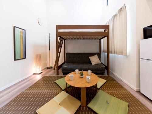 a living room with a table and a couch at TRIP POD TOJIN-MACHI A in Fukuoka