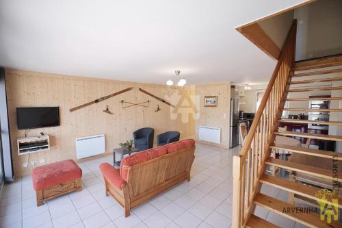 un salon avec un canapé et une télévision dans l'établissement Le Chaudefour, à Chambon-sur-Lac