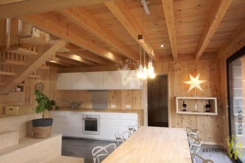 Il comprend une cuisine avec des plafonds en bois, une table et des chaises. dans l'établissement La Cabane de Marcha, à Besse-et-Saint-Anastaise