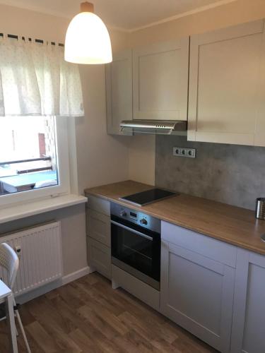 a kitchen with white cabinets and a stove top oven at 1-Bedroom apartment in city centre in Paide