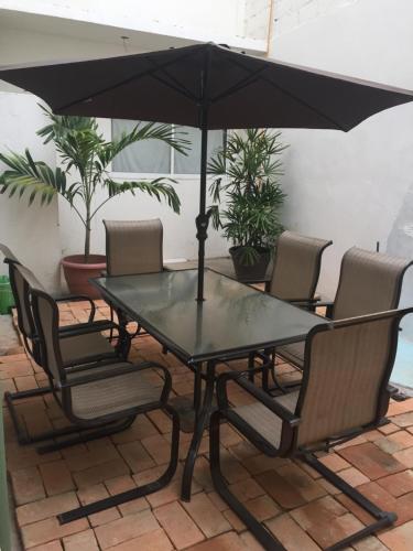 una mesa y sillas con una sombrilla en el patio en Hotel De Santiago en Chiapa de Corzo