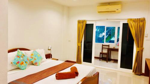 sypialnia z łóżkiem i dużym oknem w obiekcie Siray House w Phuket