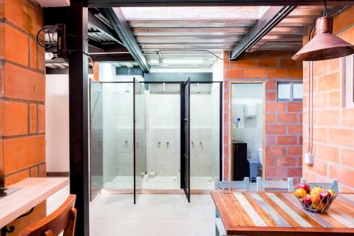 una habitación con una mesa y una puerta de cristal en Medellin Backpacker Hostel, en Medellín