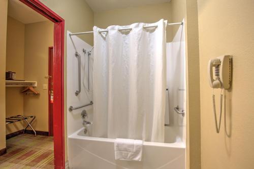 a bathroom with a shower with a white shower curtain at Super 8 by Wyndham Waterloo in Waterloo