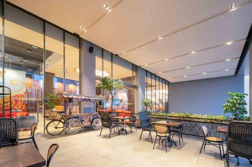 a restaurant with tables and chairs in a building at Luminor Hotel Jakarta Kota By WH in Jakarta