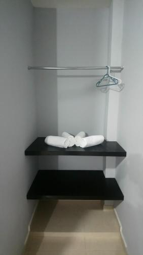 Baño con 2 toallas en una estantería negra en Hotel Popeye, en Ciudad Valles
